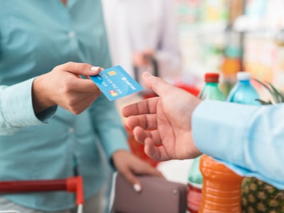 A lady giving a credit card for making payment