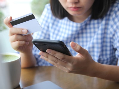 A lady using her mobile for making payment for online transactions